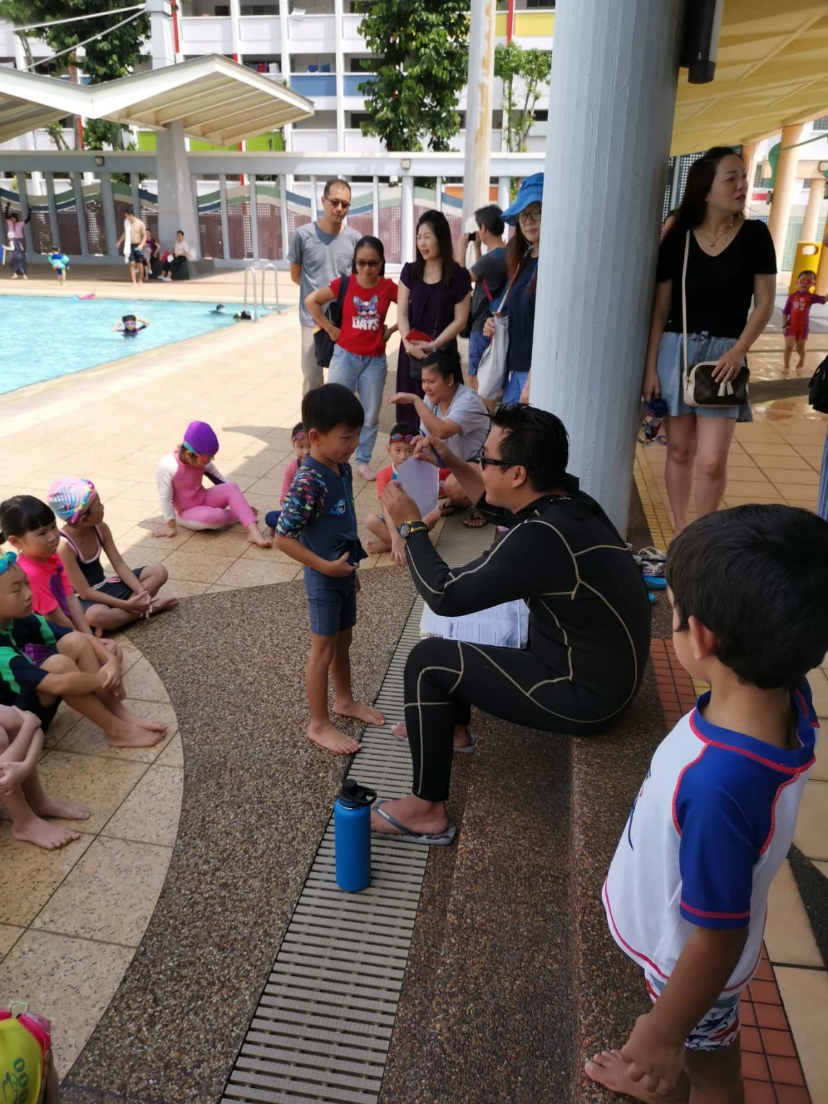 Coach Yucong briefing young swimmers at Yishun pool during 2020 SwimSafer test day